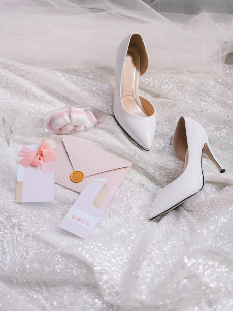 Bride's pink shoes lie next to invitations, envelope and gummies