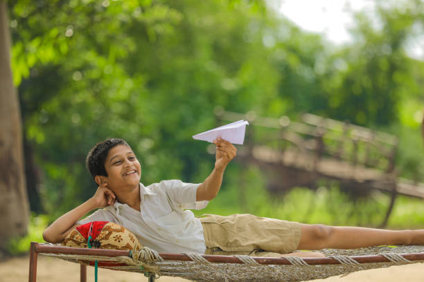 istock Cute Indian little child playing with handmade paper plane 1284348507