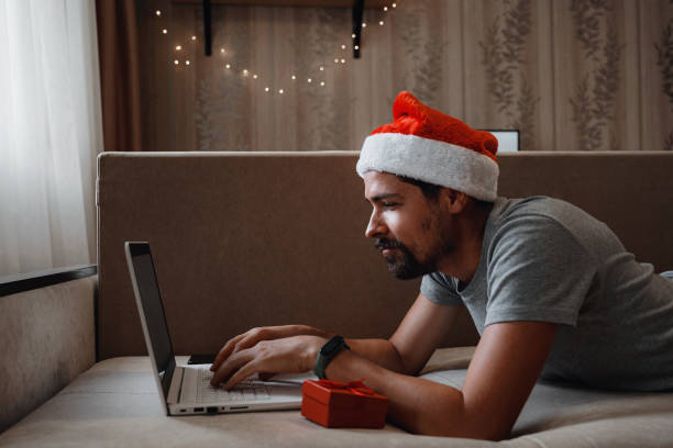 クリスマスの時に家に座っている赤いカップを持つヒップスターの男。 - christmas emotional stress shopping holiday ストックフォトと画像