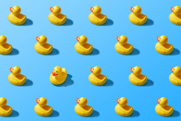 istock Trendy pop art design of a yellow rubber duck pattern from a top view. Dissenting opinion, chosen one, not like everyone else. 1284352383