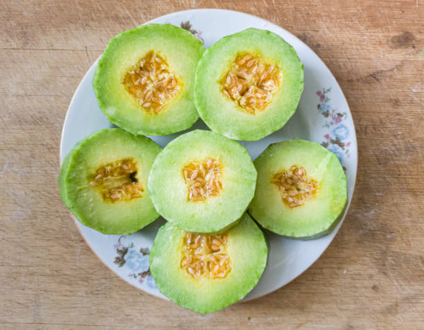 grüne melone auf schneidebrett - melon watermelon cantaloupe portion stock-fotos und bilder