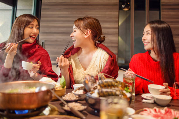 istock happy young friends  having fun in hot pot restaurant 1284356461