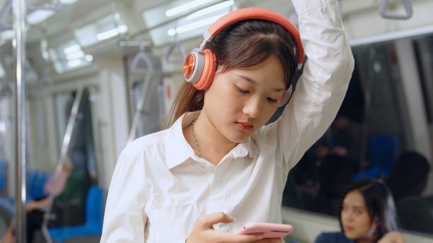 istock Young woman using mobile phone on public train 1284361312