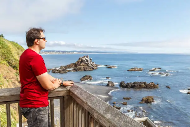 Photo of Man looking at Cobble Beach below Yaquina Headland