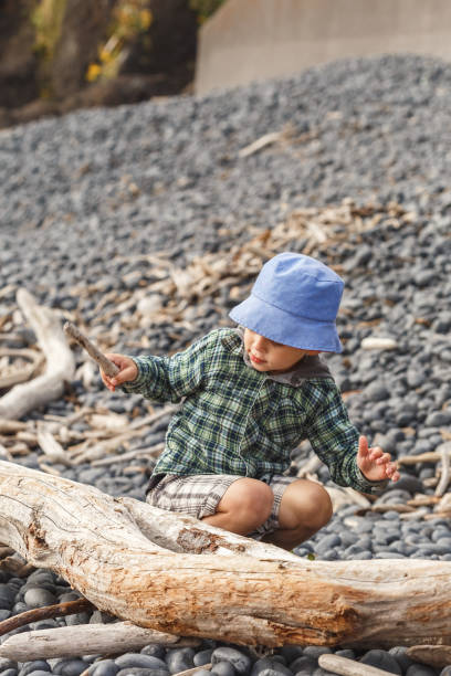 istock Boy playing with wooden sticks on the Cobble Beach 1284362145