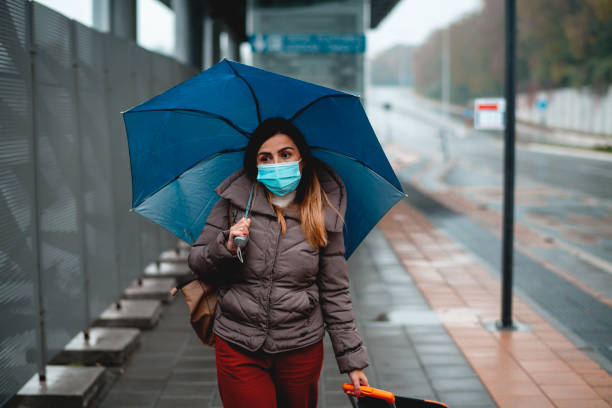 istock Young woman with protective face mask at bus station 1284362776