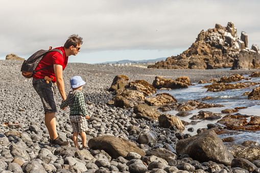 Dad and son exploring the Cobble Beach below Yaquina Head lighthouse in Newport, Oregon