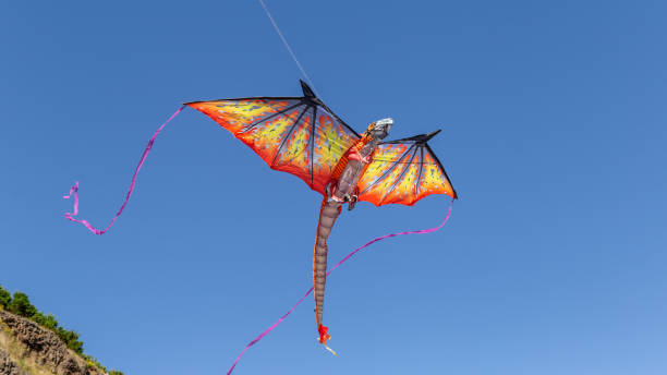 A Dragon Kite fly in the blue sky over mountains