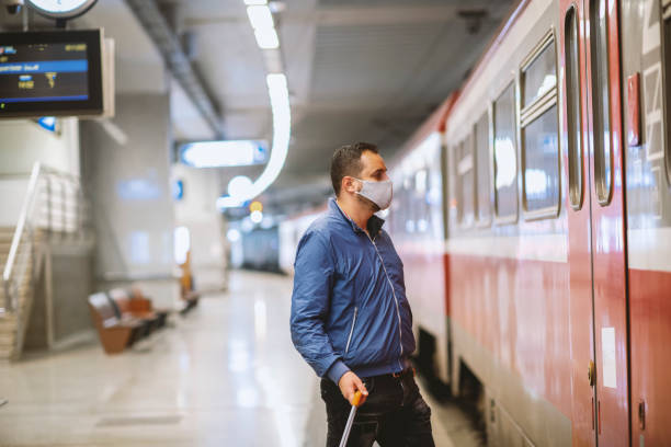 istock Young man with protective face mask waiting for subway 1284364014