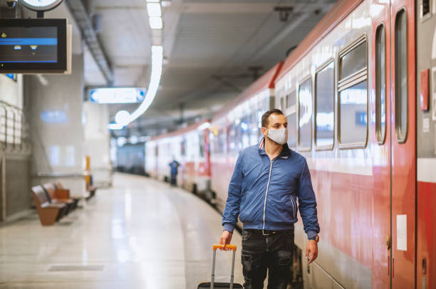 istock Young man with protective face mask waiting for subway 1284364315