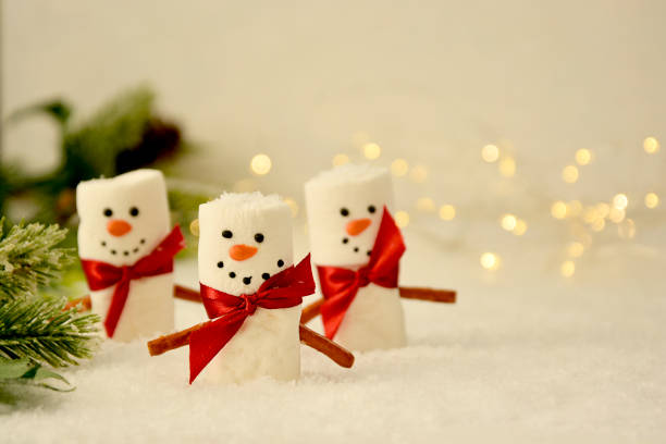 istock Marshmallow Snowmen Christmas abstract mockup with bokeh and fir branches 1284366564