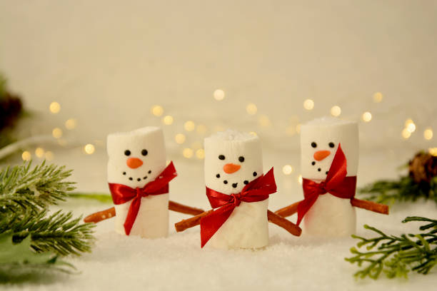 istock Marshmallow Snowmen Christmas abstract mockup with bokeh and fir branches 1284366633