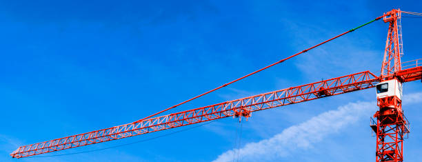 istock Construction crane tower background. Crane and building working progress. Red lifting faucet. Construction concept. Construction site with a crane. Tower crane. 1284370232