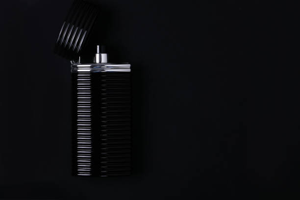 istock Mockup of black fragrance perfume bottle mockup on dark empty background. Top view. Horizontal 1284370836