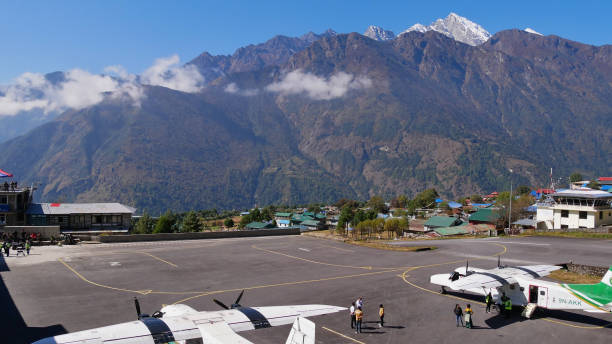 flugzeuge, die auf den start am tenzing-hillary airport warten, einem der gefährlichsten flughäfen weltweit und startpunkt des everest base camp trek im himalaya. - airfield mountain snow airport stock-fotos und bilder