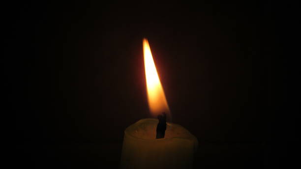 istock Close up of a candle light in the black dark 1284371447