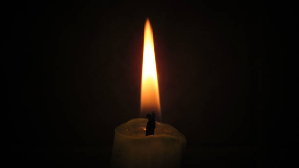 istock Close up of a candle light in the black dark 1284371463