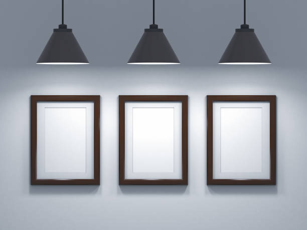 istock Black empty photo frames hanging on the wall with black lamps above. 3d rendering illustration 1284371472