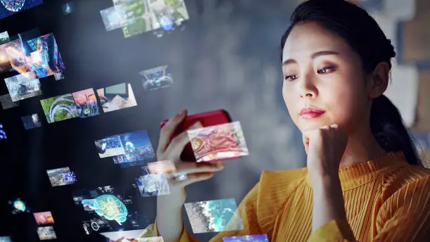 Photo of Young asian woman watching a lot of movies. Digital transformation.