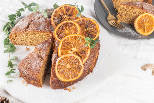 istock Christmas orange and spice cake. Decorated with dried oranges on kitchen countertop 1284373446