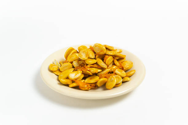 istock Pumpkin seeds in a saucer on a white background. 1284376885