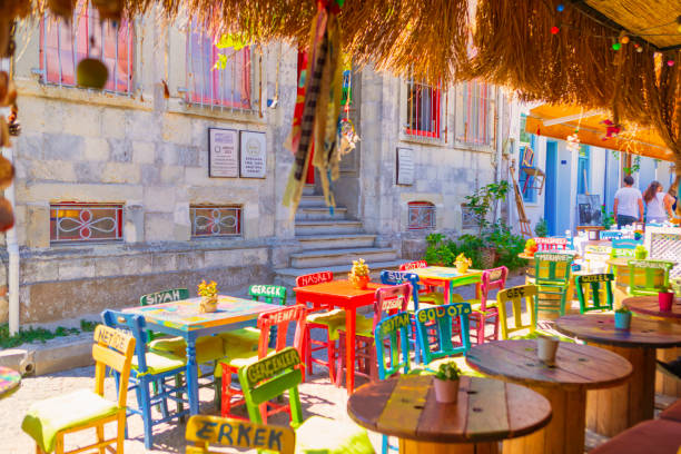 Colorful Street Cafe At Bozcaada Canakkale Turkey Çanakkale, Turkey - Aug 7, 2019: View of Bozcaada Island streets, people on the island for holiday. Bozcaada island is a municipality and district governorate in Canakkale Province, Turkey. The old name of island is tenedos. ipomoea purpurea stock pictures, royalty-free photos & images