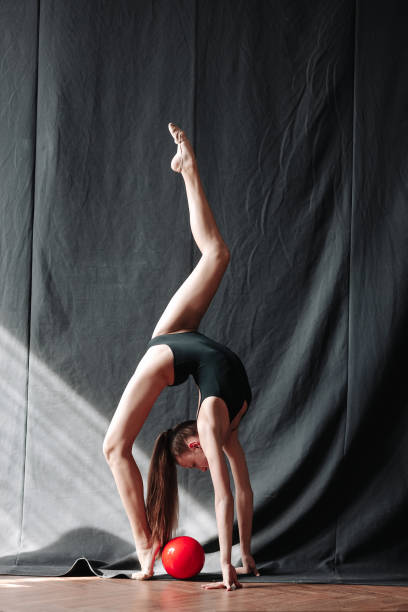 Young gymnast girl stretching and training Flexible kid doing acrobatic exercises acrobatic gymnastics stock pictures, royalty-free photos & images