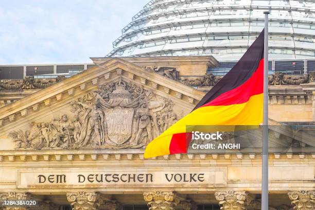 German Flag On A Background Reichstag Building The Seat Of The German Parliament Or Bundestag Berlin Mitte District Inscription In German To The German People Stock Photo - Download Image Now
