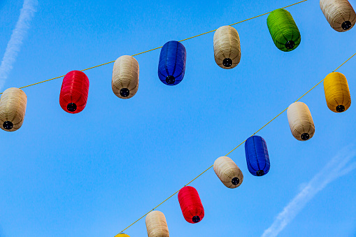 A String of Outdoor Lanterns against a Blue Sky