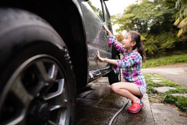 istock Cute girl washing a car 1284393149