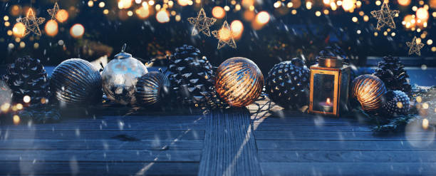 Christmas decoration in darkness Christmas decoration on a wooden table in darkness with golden bokeh and snowflakes. Background for christmas and advent concepts with space for text. poinsettia christmas candle flower stock pictures, royalty-free photos & images