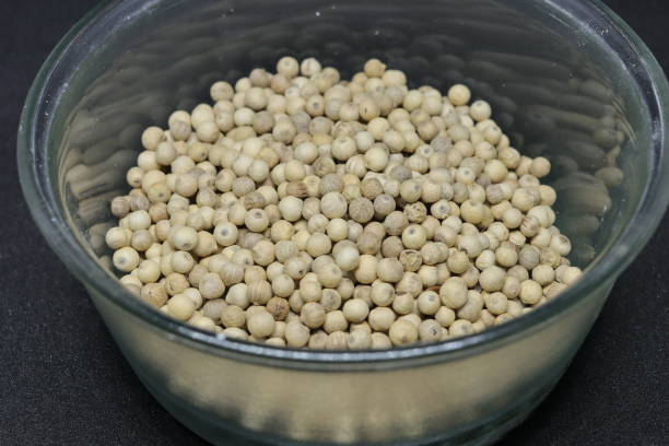istock White pepper grains isolated on black background 1284394409