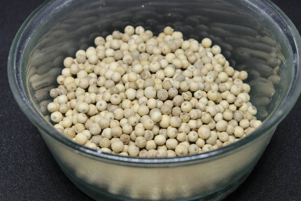 istock White pepper grains isolated on black background 1284394468