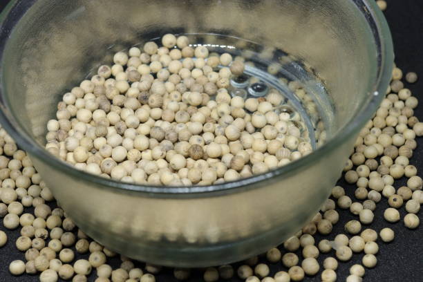 istock White pepper grains isolated on black background 1284394555