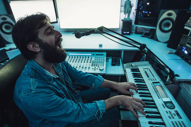 istock Male sound engineer playing synthesizer and singing in recording studio 1284399784