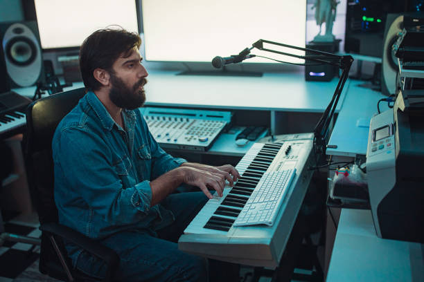 istock Male sound engineer playing synthesizer in recording studio 1284399856