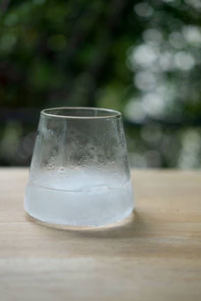 istock Glass with ice freeze on wood table with nature background 1284401017