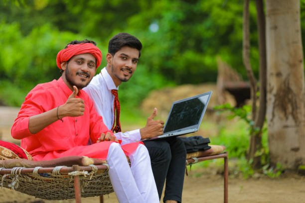 young indian farmer showing thumps up with agronomist or banker after discussion at home - child office chaos computer monitor imagens e fotografias de stock
