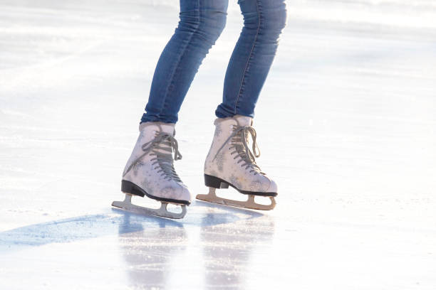 istock Female legs in skates on an ice rink 1284402833