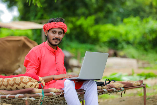 istock technology concept : Young indian farmer using laptop at home 1284403256