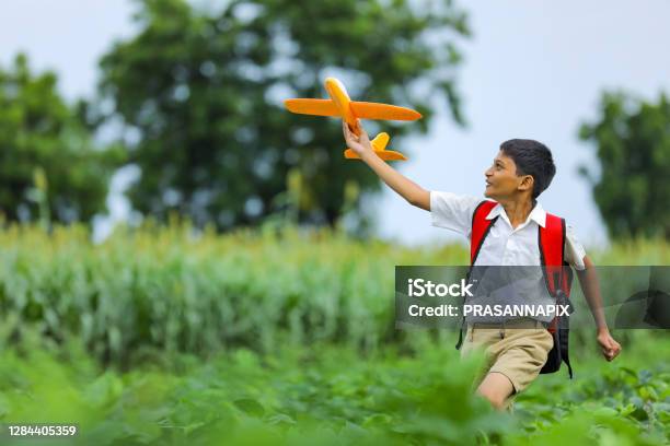 Dreams Of Flight Indian Child Playing With Toy Airplane At Green Field Stock Photo - Download Image Now