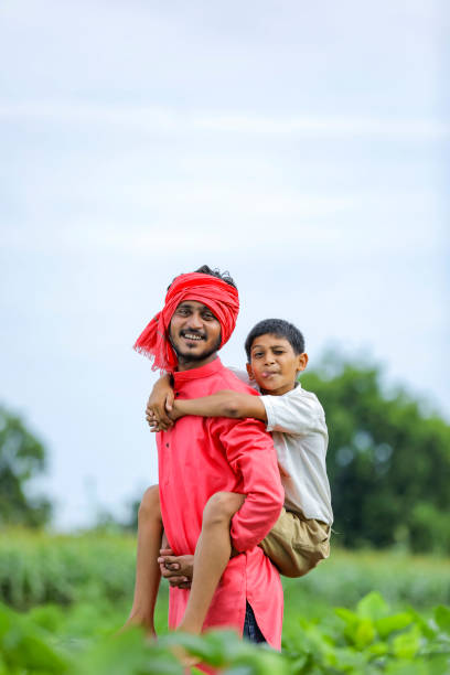 istock Indian farmer playing with his child at green field 1284407360