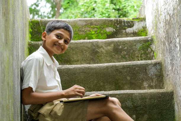 istock Indian child writing A B C D alphabet on Chalkboard 1284407983