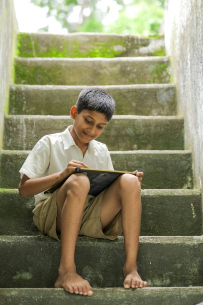 istock Indian child writing A B C D alphabet on Chalkboard 1284408206