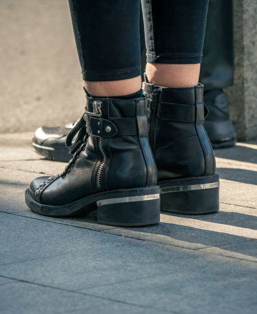 istock Woman's feet wearing black leather boots or shoes. 1284409565