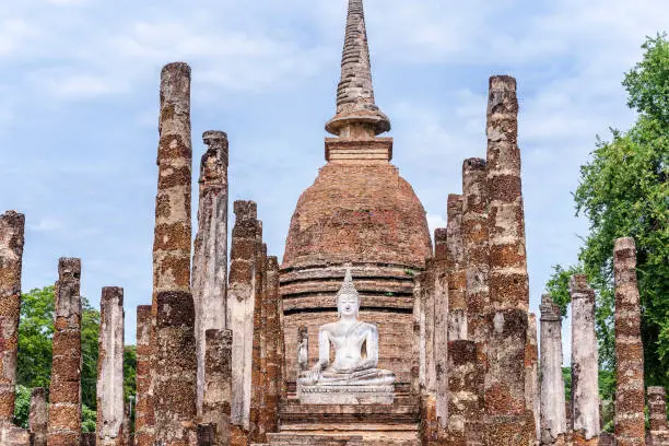 Photo of Ancient Buddha image with the ruin of temple at Sukhotai Historical Park, Sukhothai Historical Park is the UNESCO world heritage and Famous Tourist Destination in Northern Thailand