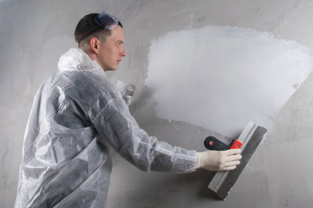 istock applying, for workers in protective uniforms, finishing putty on a concrete wall, there is a place for the inscription 1284411050