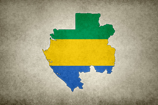 Grunge map of Gabon with its flag printed within its border on an old paper.