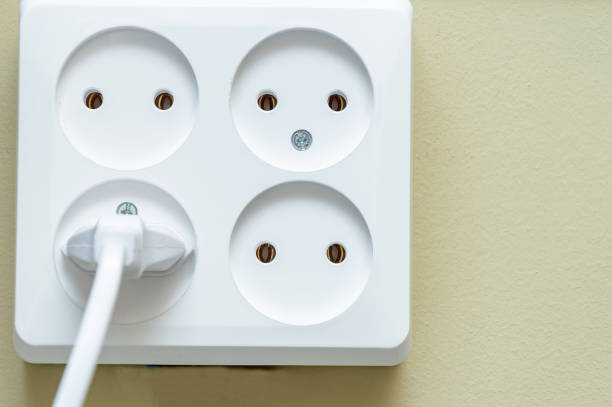 istock Electrical socket with four sockets. one of the outlets has an electric plug on a beige background close-up. 1284413019