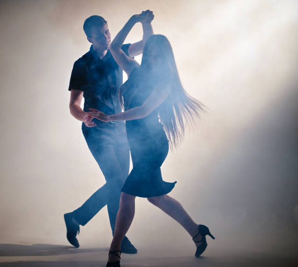 atractiva pareja de jóvenes bailarines están realizando danza latinoamericana - samba dancing fotografías e imágenes de stock